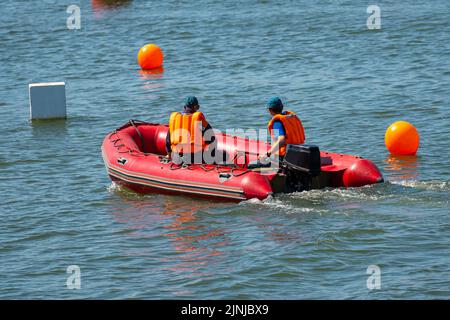 Retter auf einem roten aufblasbaren Boot patrouillieren auf dem Meer. Stockfoto