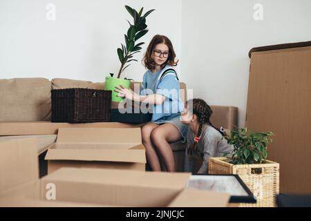 Familie packt Pappkartons in neuem Zuhause aus. Stockfoto