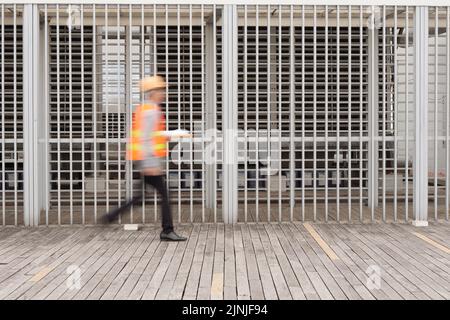 Verschwommene Bewegung des Ingenieurs, der durch die Baustelle läuft Stockfoto