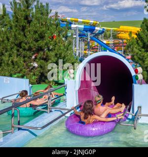 Liptovsky Mikulas, Slowakei - 4. August 2022: Menschen bereit, auf aufblasbaren in Wasserrutsche im Aquapark Tatralandia in der Slowakei gleiten Stockfoto
