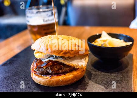 Nahaufnahme von leckeren frischen Hamburgern auf dem Tisch im Restaurant Stockfoto