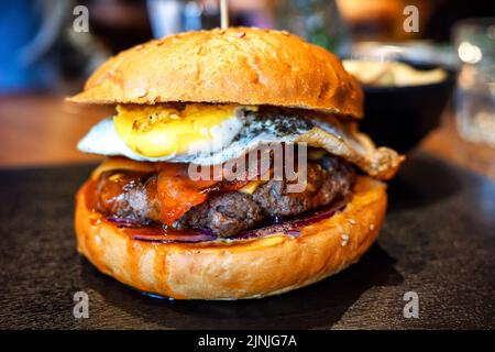 Nahaufnahme von leckeren frischen Hamburgern auf dem Tisch im Restaurant Stockfoto