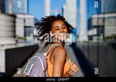 Multirassische Teenager-Mädchen zu Fuß mit Rucksack in der modernen Innenstadt während des Sommers Tag, zurück zur Schule Konzept. Stockfoto