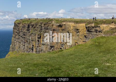 Eine Gruppe von Touristen, die auf den Klippen von Moher, Burren, Irland, wandern Stockfoto