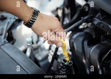 Automechaniker überprüft den Ölstand im Automotor Stockfoto