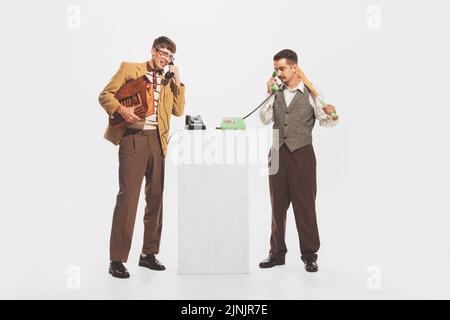 Porträt von zwei stilvollen Mann, Geschäftsleute sprechen am Telefon isoliert über weißen Studio-Hintergrund Stockfoto