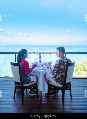 Paar Männer und Frauen beim Frühstück mit Blick auf den Ozean der Karibik St. Lucia. Männer und Frauen auf einem Luxusurlaub in St. Lucia Stockfoto