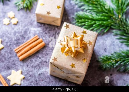 Weihnachtsgebäck und Kekse auf grauem Schreibtisch. Winterschmuck, Kiefer und Kegel. Konzept von weihnachten, Geschenke und Feiertage. Leuchtet Stockfoto