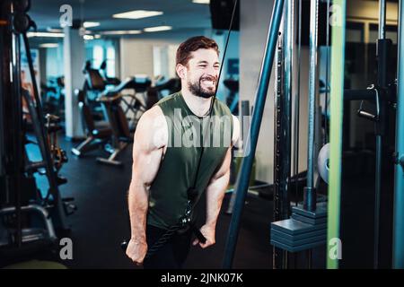 Ein Mann, der an der lat-Pull-Maschine mit Seilgriff eine Pulldown-Übung macht Stockfoto