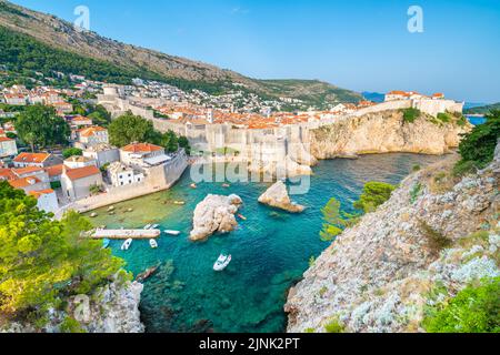 Altstadt Dubrovnik Panorama. Blick auf die Dächer der Stadt, Klippen über dem Meer und den kleinen Hafen mit Booten. Stockfoto