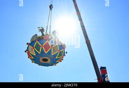 Stuttgart, Deutschland. 12. August 2022. Die Obstsäule, das Wahrzeichen des Cannstatter Wasen Volksfestes, wird nach einer zweijährigen Pause von Corona errichtet. Das Volksfest gilt nach der Münchner Wiesn als das zweitgrößte Festival seiner Art weltweit. Quelle: Bernd Weißbrod/dpa/Alamy Live News Stockfoto