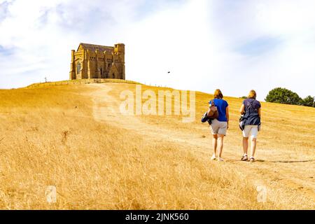 Dürre UK 2022; zwei Frauen, die durch ausgetrocknete Trockengrasfelder zur St. Catherines Chapel, Abbotsbury Dorset, gehen, Sommer 2022 in Südengland Stockfoto