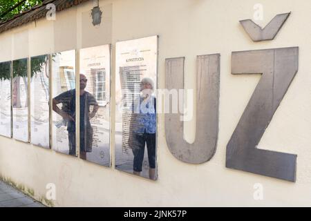 Uzupis, selbsterklärte unabhängige Republik in der Altstadt von Vilnius; Menschen, die die Verfassung als Touristenattraktion betrachten, Uzupis Vilnius Litauen. Stockfoto