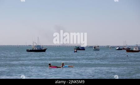 Grasbrand von Southend über die Themse mit kleinen Booten und dem Southend Pier im Mittelfeld. Hitzewelle im Sommer Stockfoto