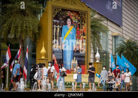 Bangkok, Bangkok, Thailand. 12. August 2022. Vor dem berühmten Einkaufszentrum Siam Paragon in Bangkok kommen die Menschen an einem großen Porträt der Königlichen Hoheit, der Königin Sirikit, vorbei. Die Königin Mutter von Thailand, ihre Königinnen Sirikit, feierte am Freitag, den 12. August 2022, ihren 90.. Geburtstag. Ihr verstorbener Ehemann, HRH, König Bhumibon, regierte über 70 Jahre, der längste aller Könige in der thailändischen Geschichte und der drittlängste der Welt. Die Mutter des heutigen Monarchen, König Vajiralongkorn, die Königin Mutter, litt unter Krankheit und hat in letzter Zeit keine öffentlichen Auftritte gemacht. (Bild: © Adryel Talamantes/ZUMA Stockfoto