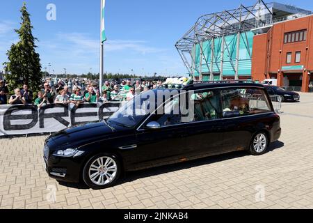 Der Leichenwagen, der den Sarg des ehemaligen keltischen Spielers John Hughes trägt, kommt im Celtic Park in Glasgow an. Bilddatum: Freitag, 12. August 2022. Stockfoto