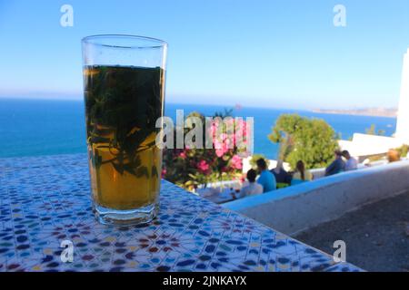 Eine Tasse marokkanischen Tee mit Minze auf einem zelligen Tisch in Tanger, Marokko Stockfoto