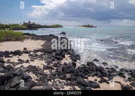 Sehr schöne Wellen, die über die Felsen am Strand der Insel Floreanda, Galapagos, Ecuador, krachen Stockfoto