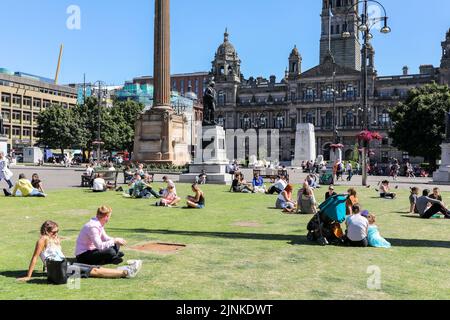 Glasgow, Großbritannien. 12. August 2022. Während die Temperaturen im Sommer 30c Arbeiter erreichen, fahren Touristen und Einheimische zum George Square, zu Bars und Restaurants im Freien, um die Sonne zu genießen und sich zu entspannen. Kredit: Findlay/Alamy Live Nachrichten Stockfoto