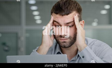 Nahaufnahme müde nachdenkliche Geschäftsmann Blick auf Laptop-Bildschirm leiden unter Überlastung Gefühl Kopfschmerzen schmerzhafte Symptom Migräne Reiben Tempel jung Stockfoto