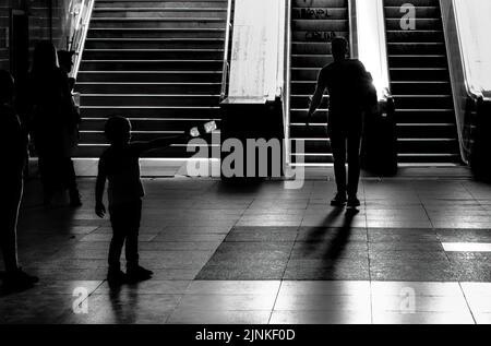 Eine Graustufenaufnahme von Menschen an der U-Bahnstation Universitate Square in Bukarest Stockfoto