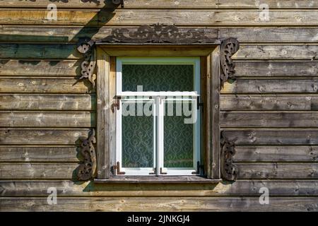 Sehr altes weißes Fenster in einer Holzhütte auf dem Land. Stockfoto