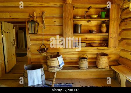 Holzhausinnenraum mit sehr alten Holzgegenständen wie Eimern und Containern. Stockfoto