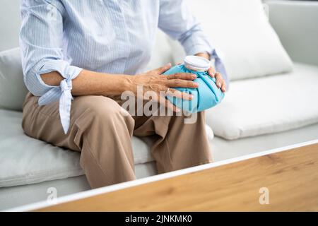 Nahaufnahme einer Frau Anwendung Cool Gel Pack auf Ihrem Knie Stockfoto