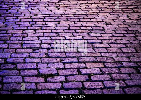 Nahaufnahme einer alten Kopfsteinpflasterstraße, einer Backsteinstraße Stockfoto