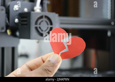 Papier gebrochenes Herz in der Hand zeigt das Konzept der Traurigkeit in jeder Beziehung wie Liebe, Freundschaft und Ehe Stockfoto