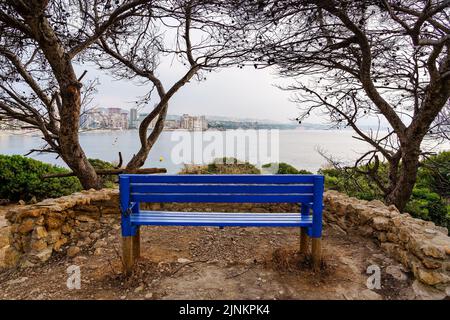 Sitzbank zum Sitzen und die Meereslandschaft mit der Stadt am Meer betrachten. Calpe Alicante. Stockfoto
