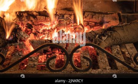 Holzkohle in einem Kamin, der im Winter angenehme Wärme verleiht. Stockfoto