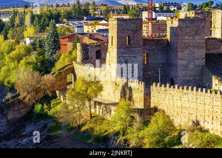 Mittelalterliche Burg mit ihrer Mauer in einem herbstlichen Sonnenuntergang. Buitrago del Lozoya, Madrid. Stockfoto