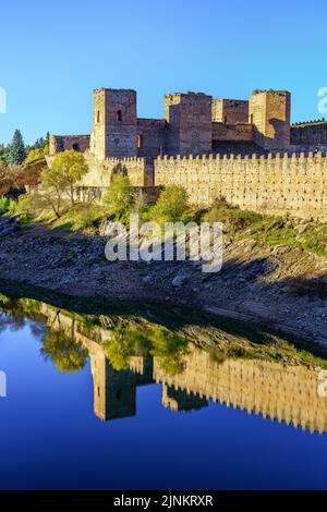 Mittelalterliche Burg und Mauer mit ihrer Spiegelung im Fluss, der daneben verläuft. Buitrago del Lozoya, Madrid. Stockfoto