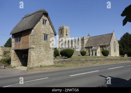 St Peter & St Paul Kirche Long Compton stammt aus dem 13.. Jahrhundert mit seinem ungewöhnlichen Lynch Gate, das unter einem alten reetgedeckten Häuschen verläuft, war umfangreich Stockfoto