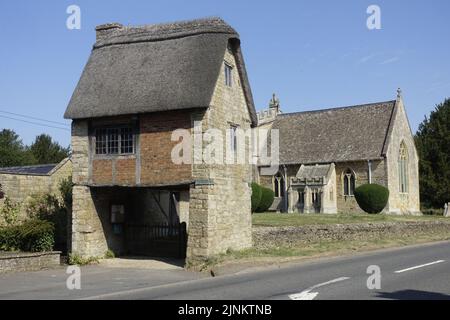 St Peter & St Paul Kirche Long Compton stammt aus dem 13.. Jahrhundert mit seinem ungewöhnlichen Lynch Gate, das unter einem alten reetgedeckten Häuschen verläuft, war umfangreich Stockfoto