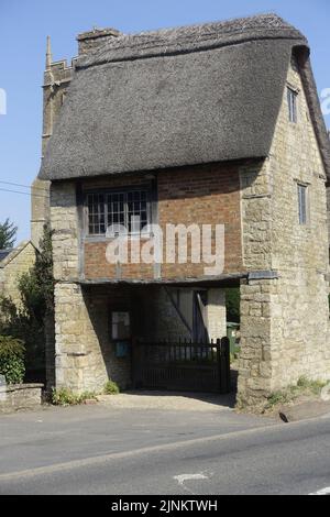 St Peter & St Paul Kirche Long Compton stammt aus dem 13.. Jahrhundert mit seinem ungewöhnlichen Lynch Gate, das unter einem alten reetgedeckten Häuschen verläuft, war umfangreich Stockfoto