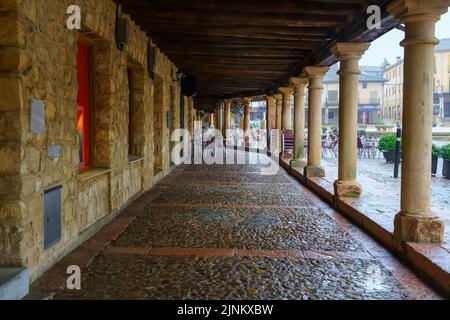 Bögen mit alten Steinsäulen auf dem Hauptplatz einer mittelalterlichen Stadt. Riaza Segovia. Stockfoto
