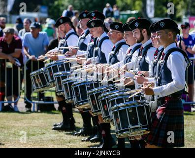 Glasgow, Großbritannien. 12. August 2022. Die World Pipe Band Championship wurde nach der Aussetzung im Jahr 2019 aufgrund von Covid-Beschränkungen wieder aufgenommen, und in diesem Jahr nehmen 150 Pfeifenbänder aus der ganzen Welt Teil. Der Wettbewerb findet über 2 Tage statt, und am zweiten Tag (Samstag) wird aufgrund des warmen und sonnigen Wetters erwartet, dass er Rekordmengen anzieht. Trommler mit Police Scotland Pipe Band. Kredit: Findlay/Alamy Live Nachrichten Stockfoto