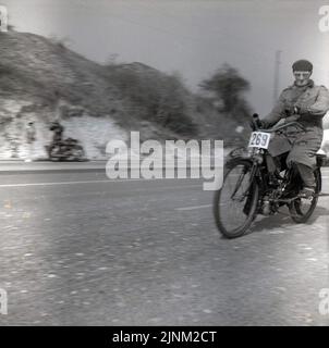 1960, historisch, ein männlicher Konkurrent in Mantel und Hut, Nr. 269, der mit seinem alten motorisierten Fahrrad auf der Brighton Road (A23) unterwegs war und an der Veteranenwagenfahrt London-Brihton, East Sussex, England, Großbritannien, teilnahm. Der Lauf ist für Fahrzeuge geöffnet, die vor 1905 gebaut wurden. Stockfoto