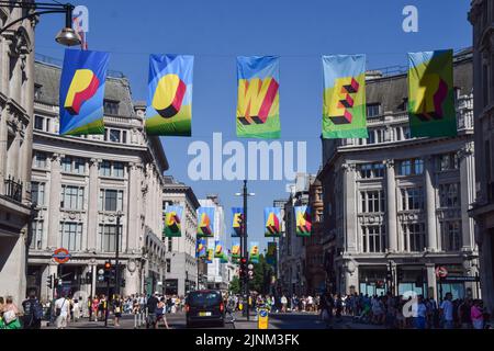 London, Großbritannien. 12.. August 2022. Entlang der Oxford Street wurde eine neue Kunstinstallation mit Fahnen mit der Aufschrift „Time for Clean Power“ aus recyceltem Ozeanplastik installiert, um den Wechsel zu erneuerbaren Energien zu fördern. Die Installation wurde vom britischen Künstler Morag Myerscough entworfen, der Teil einer von #TOGETHERBAND finanzierten Kampagne ist. Kredit: Vuk Valcic/Alamy Live Nachrichten Stockfoto