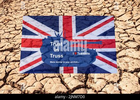 Liz Truss im Panzer auf UK Flagge und rissige Erde, Dürre, Hintergrund. Steuersenkungen, Klimawandel-Tory, konservative Parteiführung Kampagnenkonzept. Stockfoto