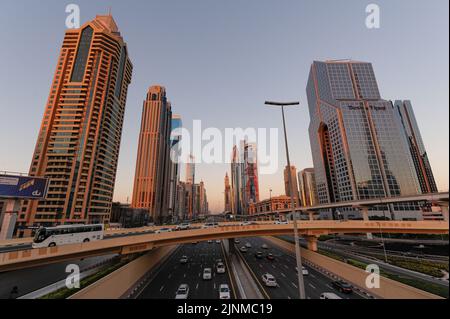 Ein breites Bild des Verkehrs und der Gebäude entlang der Sheikh Zayed Road, der längsten Autobahn in Dubai und den Vereinigten Arabischen Emiraten. Stadtbild bei Sonnenuntergang. Stockfoto