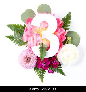 Kreatives Layout mit bunten Blumen, Blättern und Nummer drei isoliert auf weißem Hintergrund. Jubiläumskonzept. Flach liegend. Stockfoto