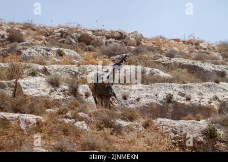 Nablus, Westjordanland, Palästina. 2. August 2022. Ein israelischer Soldat feuert während der Demonstration gegen israelische Siedlungen im Dorf Beit Dajan in der Nähe der Stadt Nablus im Westjordanland Tränengaskanister auf die palästinensischen Demonstranten. (Bild: © Nasser Ishtayeh/SOPA Images via ZUMA Press Wire) Stockfoto