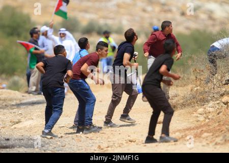 Nablus, Westjordanland, Palästina. 2. August 2022. Palästinensische Demonstranten schleuderten Steine auf die israelischen Soldaten während der Demonstration gegen israelische Siedlungen im Dorf Beit Dajan in der Nähe der Stadt Nablus im Westjordanland. (Bild: © Nasser Ishtayeh/SOPA Images via ZUMA Press Wire) Stockfoto