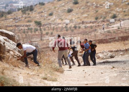 Nablus, Westjordanland, Palästina. 2. August 2022. Palästinensische Demonstranten schleuderten Steine auf die israelischen Soldaten während der Demonstration gegen israelische Siedlungen im Dorf Beit Dajan in der Nähe der Stadt Nablus im Westjordanland. (Bild: © Nasser Ishtayeh/SOPA Images via ZUMA Press Wire) Stockfoto