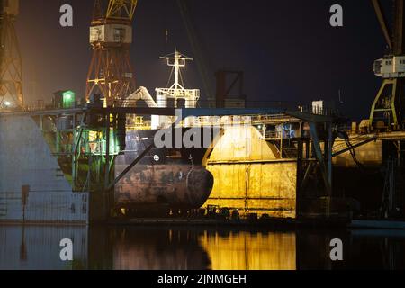 Schiff in einem Trockendock, das im Hafen von Riga, Lettland, aus dem Wasser gehoben wurde. Stockfoto