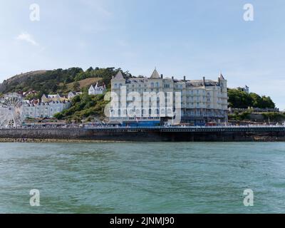 Llandudno, Clwyd, Wales, August 07 2022: Grand Hotel und großes Rad vom Meer aus gesehen. Stockfoto