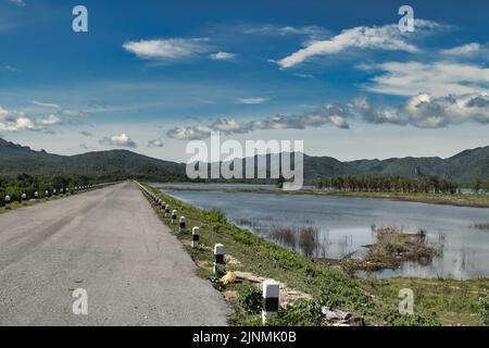 Straße entlang eines der vielen Stauseen in der bergigen Provinz Lampang, Thailand, nicht weit von der Stadt Li. Stockfoto